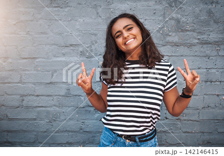 Brick, wall and peace sign for girl, smile and hands for gesture, outdoor and break for weekend. Proud, excited and student on holiday, morning and happiness on face, model and city of New York 142146415