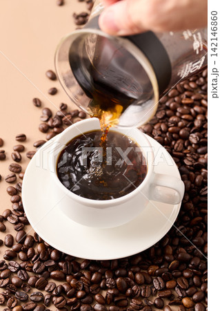 カップにコーヒーを注ぐ カップにコーヒーを注ぐ 142146860