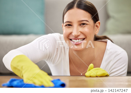 Cleaning, table and portrait of woman in home with cloth for hygiene, disinfection and dust on furniture. Housekeeping, spring clean and happy person with products for chores, housework and wellness 142147247