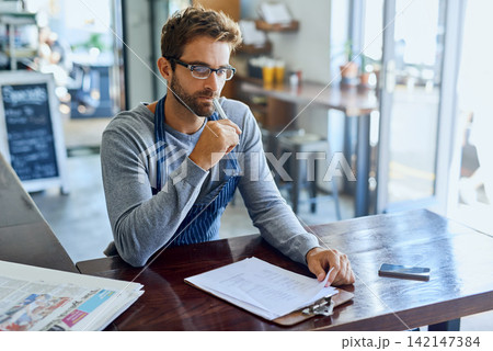 Cafe, barista and man with clipboard in restaurant for price stock, checklist and review of inventory. Small business, coffee shop and employee with thinking for supply chain, feedback and planning Cafe, barista and man with clipboard in restaurant for price stock, checklist and review of inventory. Small business, coffee shop and employee with thinking for supply chain, feedback and planning 142147384