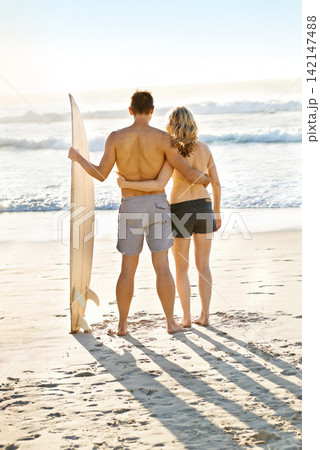 Couple, surfer and search for waves in summer at beach for vacation, exercise and fitness in ocean. Man, woman and sport for training, challenge and adventure on holiday by the sea, sand and nature. Couple, surfer and search for waves in summer at beach for vacation, exercise and fitness in ocean. Man, woman and sport for training, challenge and adventure on holiday by the sea, sand and nature. 142147488