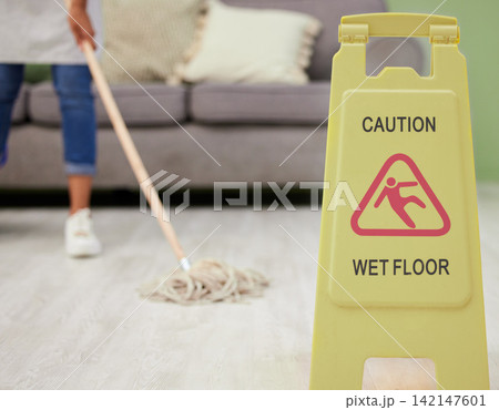 Person, mopping and caution sign for wet floor, slippery and housekeeping maintenance for hygiene or disinfecting. housekeeper, cleaning and hospitality service in living room of home with warning. 142147601