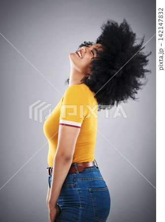 African woman, hair flip and side view for trendy fashion, style or comfort for vibrant, playful or aesthetic. Fashionista, happy and cheerful in studio with jean and bold bright cotton tshirt 142147832