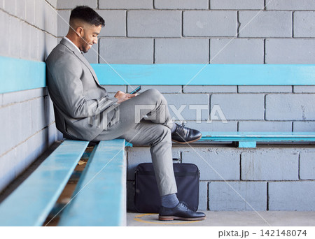 Business man, phone and bench at station for travel, check train schedule and browse on app in outdoors. Male person, relax and employee for commute to work, typing and internet for ticket website Business man, phone and bench at station for travel, check train schedule and browse on app in outdoors. Male person, relax and employee for commute to work, typing and internet for ticket website 142148074