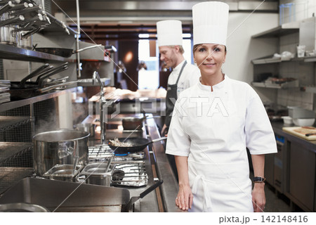 Smile, chef and portrait of woman in kitchen for hospitality service, career and cuisine at restaurant. Fine dining, happy and face of cook in food industry for catering, culinary and job in Italy Smile, chef and portrait of woman in kitchen for hospitality service, career and cuisine at restaurant. Fine dining, happy and face of cook in food industry for catering, culinary and job in Italy 142148416