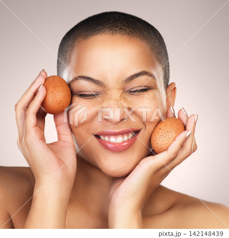 Hydration, skincare and woman with eggs in studio for natural, cosmetic and facial treatment. Wellness, health and female model with poultry for face dermatology routine isolated by gray background. 142148439