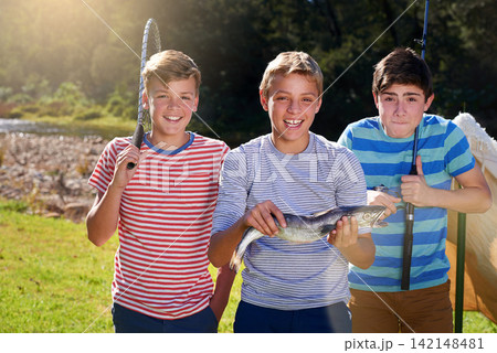 Portrait, boys and friends with fish and reel, smile and proud on camping holiday. Face, happy and rod and net with gear for fun hobby, children and fishing dinner caught on vacation by river Portrait, boys and friends with fish and reel, smile and proud on camping holiday. Face, happy and rod and net with gear for fun hobby, children and fishing dinner caught on vacation by river 142148481