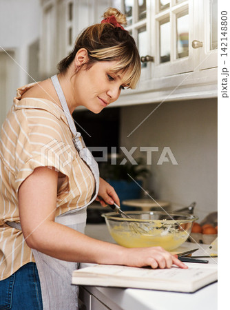 Baking, book and recipe with woman in kitchen of home for guide, instructions or reading steps. Cooking, food and small business bakery with entrepreneur chef at counter of apartment for startup 142148800