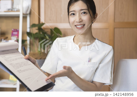 サロンで施術の説明をする若い女性 サロンで施術の説明をする若い女性 142148956
