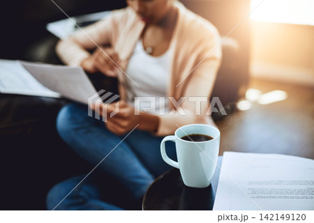 Reading, paperwork and person in home with coffee and relax with review of investment report. Wealth, savings or woman with plan for future, income and learning from bills, taxes or research info Reading, paperwork and person in home with coffee and relax with review of investment report. Wealth, savings or woman with plan for future, income and learning from bills, taxes or research info 142149120