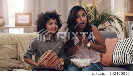 Child, mother and couch for watching baseball game with popcorn, glove and support for sports team. Mom, young boy and streaming sport channel in home with excited, television and competition on tv 142150035