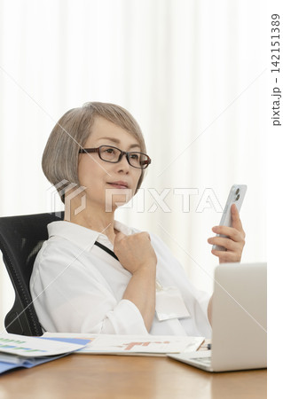 オフィスで仕事をするシニア女性 オフィスで仕事をするシニア女性 142151389