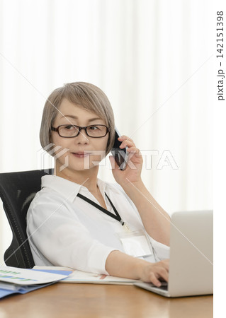オフィスで仕事をするシニア女性 142151398