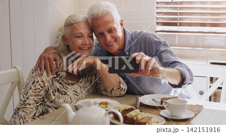 Elderly couple, love and selfie in kitchen in home with smile, retirement or bonding in marriage. Morning, happy and social media for profile picture, video call or mature people with breakfast 142151916