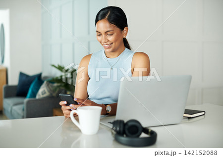 Laptop, coffee and woman with phone in kitchen networking on website, internet or mobile app. Technology, smile and female person typing email on cellphone by counter with computer in apartment. 142152088