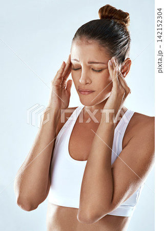 Frustrated woman, headache and stress with pain in anxiety, depression or burnout on a gray studio background. Tired or exhausted female person or athlete with migraine or mental health after workout 142152304