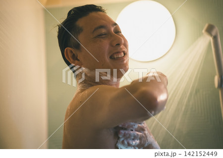 シャワーで脇の下を笑顔で洗う男性のバスタイム シャワーで脇の下を笑顔で洗う男性のバスタイム 142152449