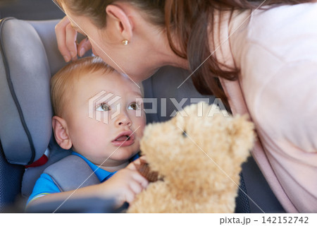 Travel, safety and mom with baby in car seat on road trip, journey or motor security insurance. Child, lock and seatbelt in vehicle for transport protection and kiss kid with teddy bear and toys 142152742