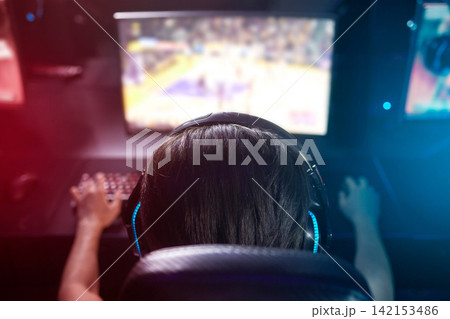 Computer, screen and gamer with headphones, esports or live stream on monitor from back. Content creator, influencer or streamer with headset for online challenge, video game or playing at night. Computer, screen and gamer with headphones, esports or live stream on monitor from back. Content creator, influencer or streamer with headset for online challenge, video game or playing at night. 142153486