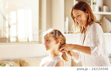 Mom, girl and hair care in home for grooming with smile, care and love in morning with connection. Hairstyle, mother and daughter with bonding, happy and relax in lounge for hygiene in family house Mom, girl and hair care in home for grooming with smile, care and love in morning with connection. Hairstyle, mother and daughter with bonding, happy and relax in lounge for hygiene in family house 142154340