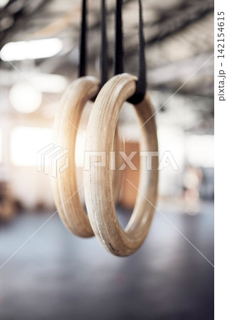 Gymnastic rings, gym and workout for exercise, fitness and strong or power challenge for training. Equipment, tool and flexibility harness or sports for wellness, arena and gear for competition 142154615