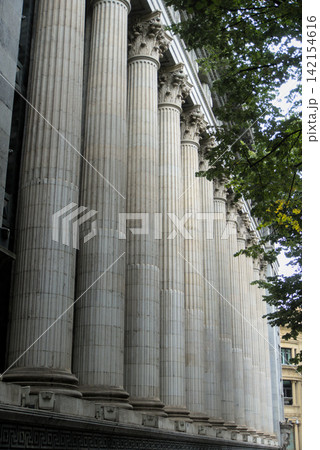 Fluted stone columns and carved capitals of a colonnade seen from below Fluted stone columns and carved capitals of a colonnade seen from below 142154616