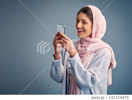 Muslim, woman and online with phone on social media live stream and post feedback on web. Contact, communication and girl chat on internet with network on smartphone in studio background or mockup Muslim, woman and online with phone on social media live stream and post feedback on web. Contact, communication and girl chat on internet with network on smartphone in studio background or mockup 142154870