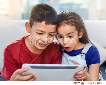 Tablet, kids and siblings on couch for play, online and esports for entertainment. Technology, streaming and internet for video wow expression in lounge, gaming and digital on touchscreen in home Tablet, kids and siblings on couch for play, online and esports for entertainment. Technology, streaming and internet for video wow expression in lounge, gaming and digital on touchscreen in home 142154885