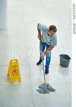 Man, janitor and mopping office for cleaning job or hygiene with caution sign with water, soap or bacteria. Male person, disinfection and corporate building as service for dirty, wellness or labor 142155547