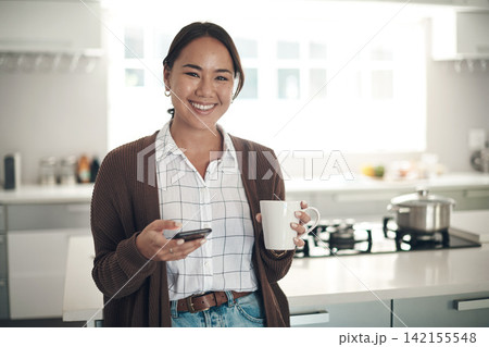 Portrait, Asian woman or coffee to relax, phone or browse on social media, website or app in kitchen. Gen z girl, smile or smartphone to drink, tea or update of post to connect at weekend of leisure 142155548