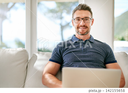 Smile, laptop and portrait of man on sofa working on freelance creative project at apartment. Happy, glasses and mature male writer with computer for research online with blog in living room at home. Smile, laptop and portrait of man on sofa working on freelance creative project at apartment. Happy, glasses and mature male writer with computer for research online with blog in living room at home. 142155658