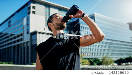 City, tired or man drinking water on break in exercise, running workout or fitness training. Male athlete, relax or thirsty sports runner with liquid bottle for wellness or hydration in Australia City, tired or man drinking water on break in exercise, running workout or fitness training. Male athlete, relax or thirsty sports runner with liquid bottle for wellness or hydration in Australia 142156639