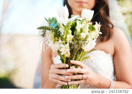 Woman, bride and hands with bouquet of flowers for wedding, marriage or ceremony in outdoor nature. Closeup of female person with bunch of white roses in dress for love, tradition or summer bloom 142156782