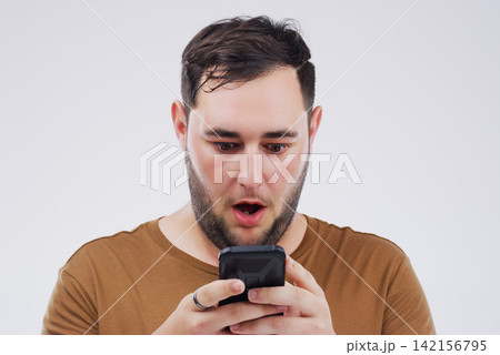 Man, wow face and smartphone on studio background for reading website with omg expression, social media and online scam. Male person, mobile and surprise by grey backdrop for news website and shocked Man, wow face and smartphone on studio background for reading website with omg expression, social media and online scam. Male person, mobile and surprise by grey backdrop for news website and shocked 142156795