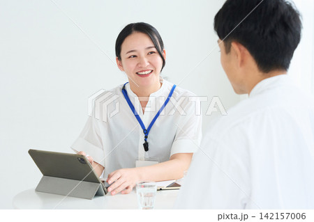 説明する女性スタッフと男性 説明する女性スタッフと男性 142157006