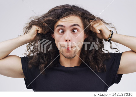 Gen z man, crazy and funny in studio for face, emoji and ear pull by white background. Male person, comedian and emotion for joke, prank and silly for humour and laugh on backdrop for comic gesture 142157036