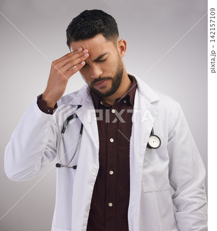 Studio, man or doctor in pain of headache, burnout and mental health of medical employee. Tired, healthcare male worker and stress with migraine, anxiety and overworked pressure by white background 142157109