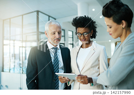 Business team, tablet and talking or planning in office for communication, collaboration and progress report. People, notebook or tech meeting in workplace for teamwork, partnership or diversity 142157990