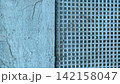 Grunge background with weathered blue textured wall and perforated metal grid 142158047