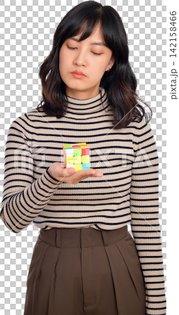 Asian woman holding colorful cube with thoughtful expression in striped sweater and brown skirt Asian woman holding colorful cube with thoughtful expression in striped sweater and brown skirt 142158466