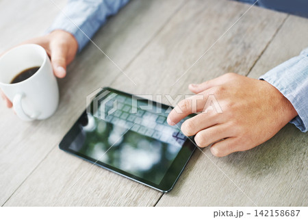 Coffee, table and hand of man with tablet for cryptocurrency, global trading and stock market. Finance, person and trader with tech on desk for investment, planning and news on economy in high angle Coffee, table and hand of man with tablet for cryptocurrency, global trading and stock market. Finance, person and trader with tech on desk for investment, planning and news on economy in high angle 142158687