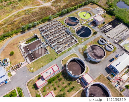 Water treatment facility located near a city helps clean and manage wastewater during the day Water treatment facility located near a city helps clean and manage wastewater during the day 142159229
