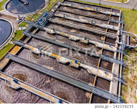 Water treatment facility uses large tanks and channels to clean wastewater during the day 142159235