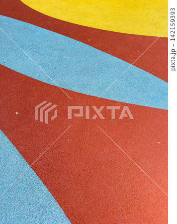 Colorful playground surface with red, blue, and yellow sections and curved shapes in bright patterns Colorful playground surface with red, blue, and yellow sections and curved shapes in bright patterns 142159393