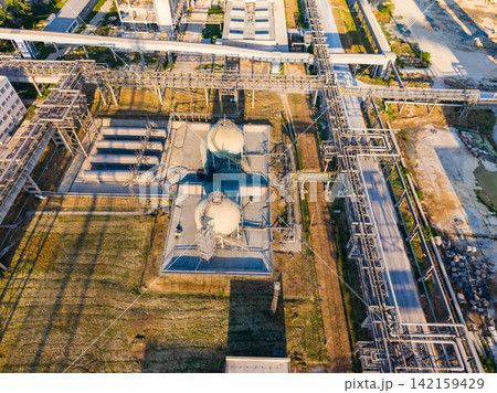 Industrial site with tanks and infrastructure in a rural area during daytime Industrial site with tanks and infrastructure in a rural area during daytime 142159429