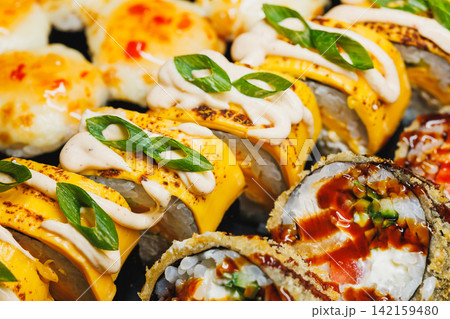 Sushi rolls on a plate with toppings and sauces arranged for serving Sushi rolls on a plate with toppings and sauces arranged for serving 142159480