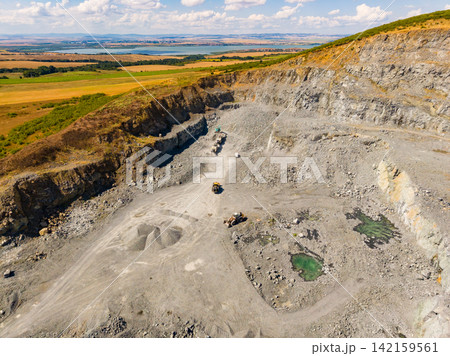 Granite quarry located in a vast landscape with heavy machinery working during daylight hours 142159561