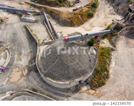 Granite quarry with machinery and piles of stone at a work site during the day 142159570