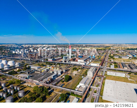 View of an industrial area with factories, smoke stacks, and storage tanks on a clear day in a developed region 142159621