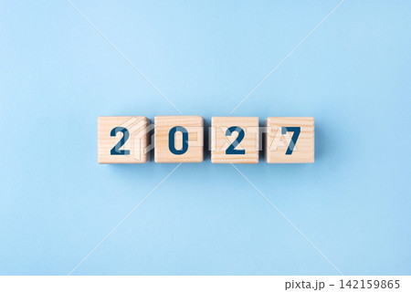 Wooden cubes with numbers of the New Year 2027 on a blue background Wooden cubes with numbers of the New Year 2027 on a blue background 142159865